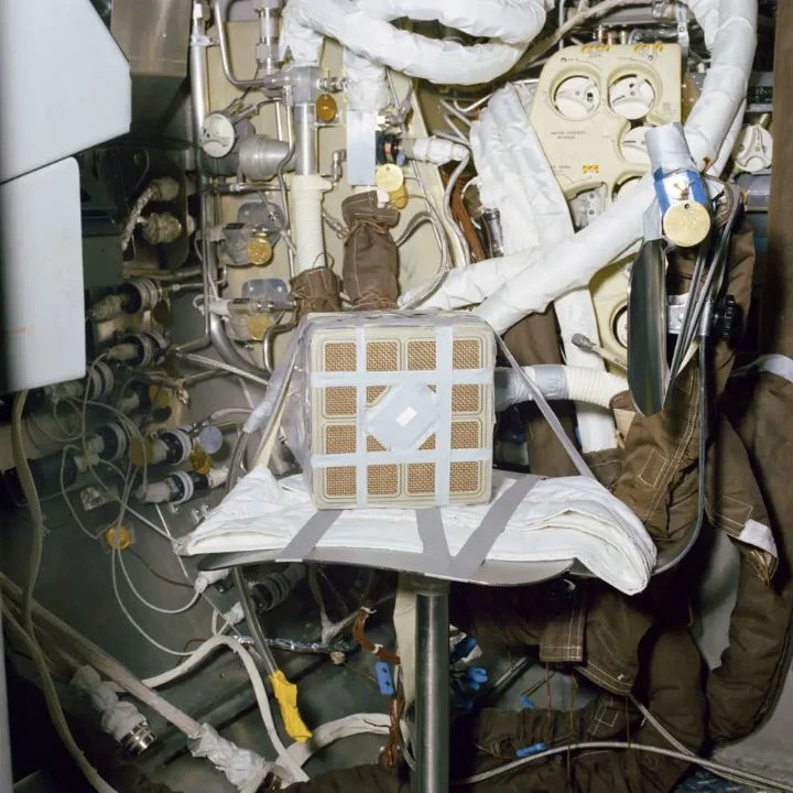 A square lithium hydroxide canister and connected hoses in a ground test installation.