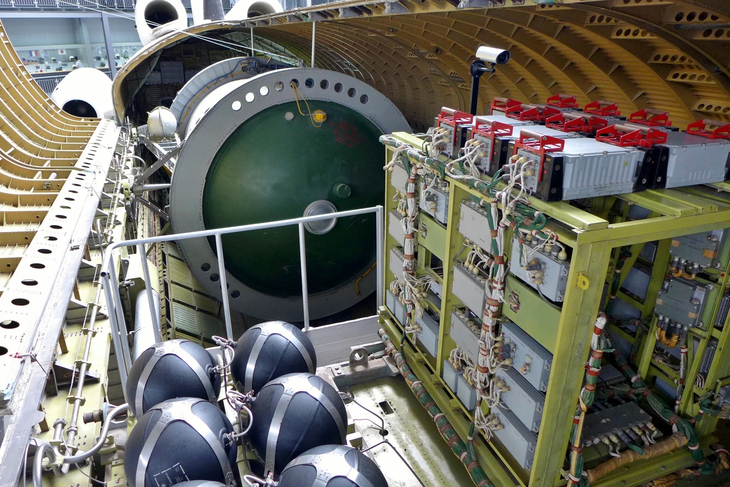 An open compartment in the Buran OK-GLI test analogue shows racks of equipment, bundled wiring, spherical tanks and the cabin bulkhead.