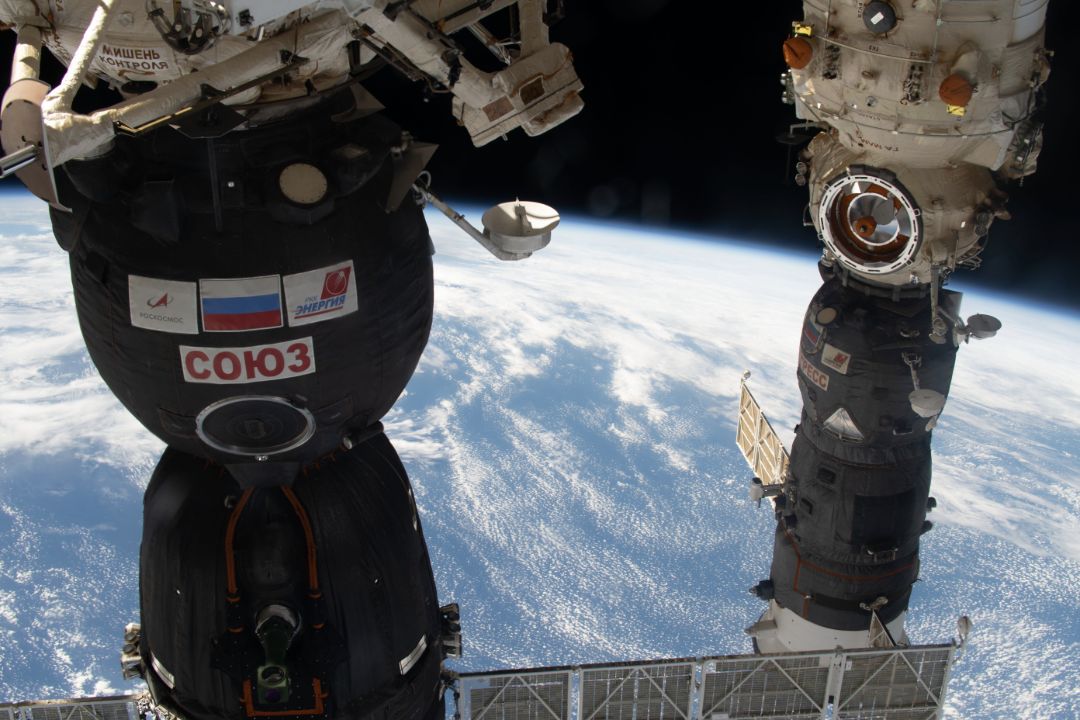 Soyuz MS-19 and Progress 78 docked to the ISS above Earth.