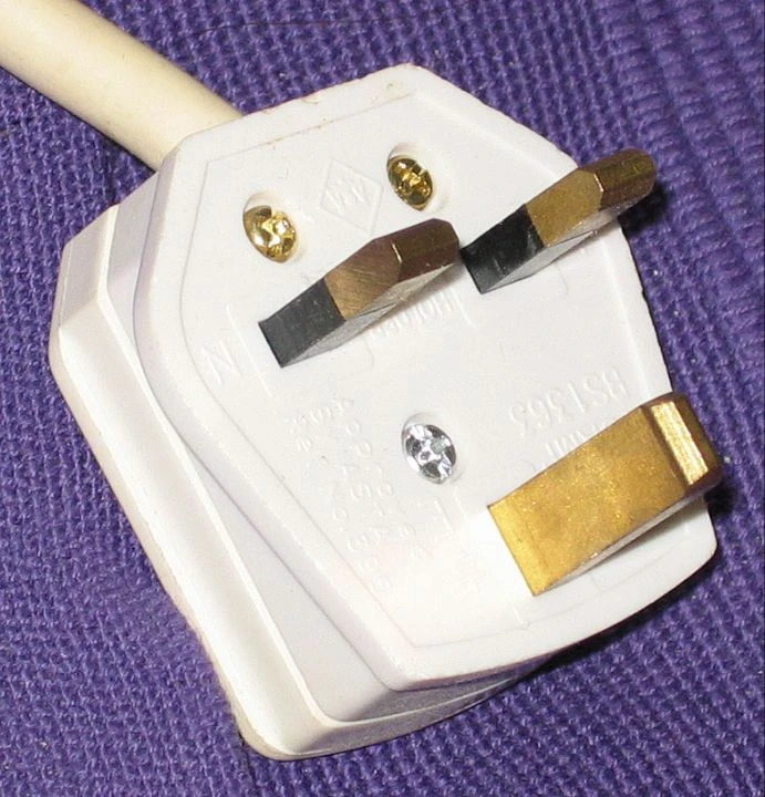 A British three-pin plug with rectangular metal pins and partly insulated live and neutral pins.