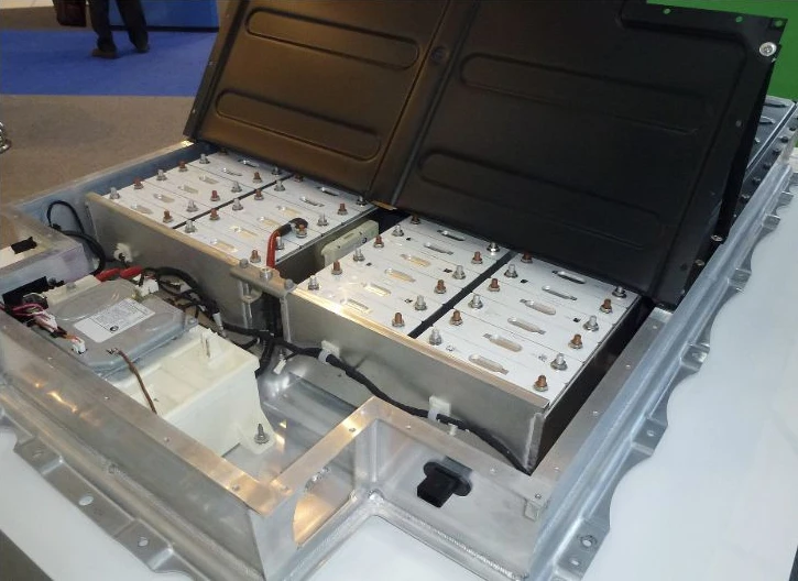 An open battery pack displays several modules in a metal enclosure.