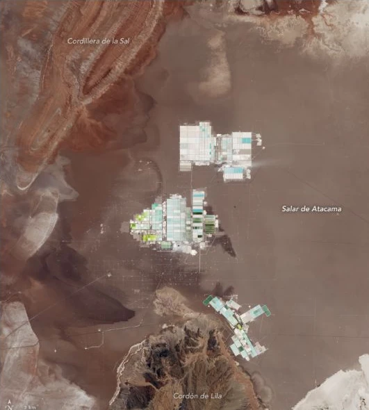 Satellite image of clusters of pale rectangular evaporation ponds in Chile’s Salar de Atacama.