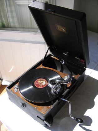 An open portable gramophone with a record on its turntable
