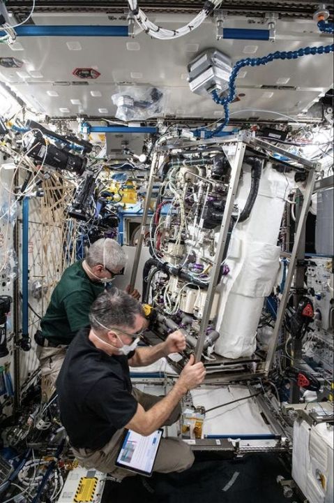 ISS astronauts working at carbon dioxide removal equipment.