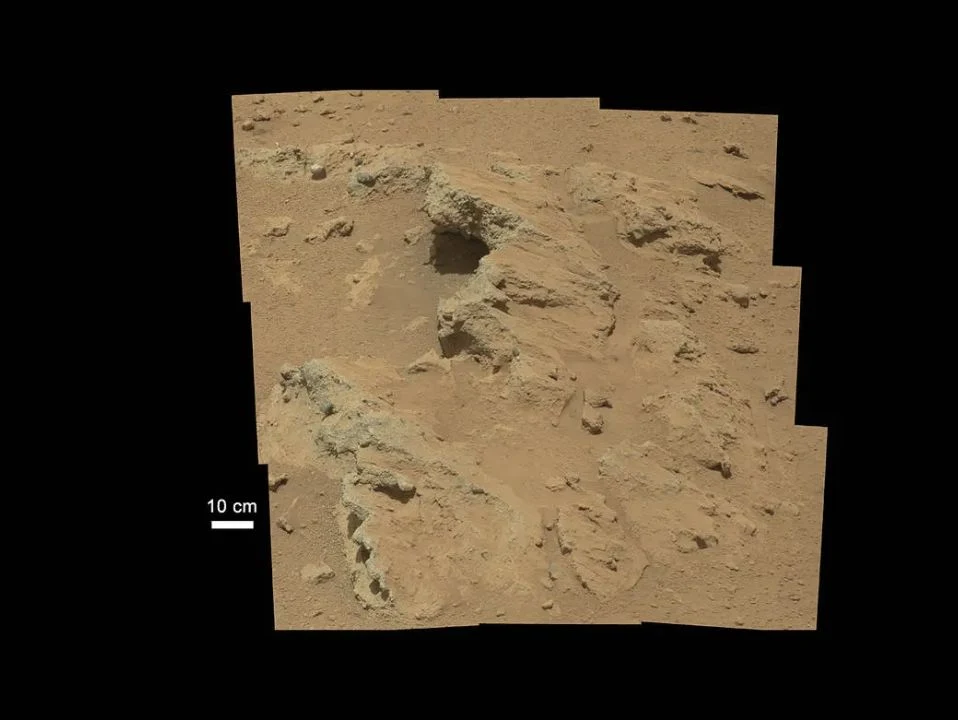 A tilted slab of Hottah conglomerate and surrounding gravel on Mars, with the original ten-centimeter scale.