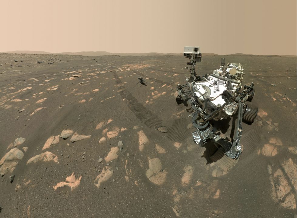 Perseverance rover and Ingenuity helicopter on the rocky surface of Mars.