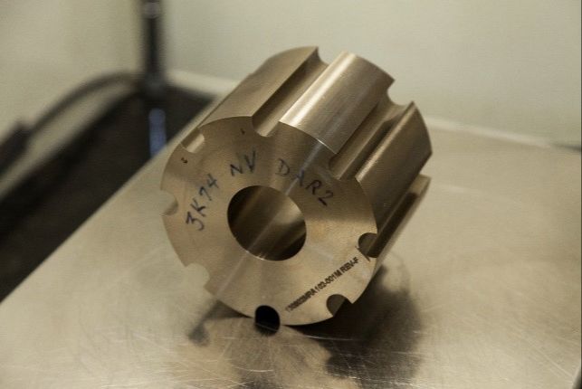 Metal core piece with a central bore and grooves for heat pipes.