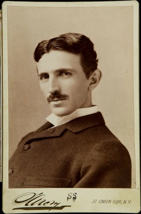 Sepia cabinet photograph of Nikola Tesla, turned slightly to his left, on a Sarony studio card.