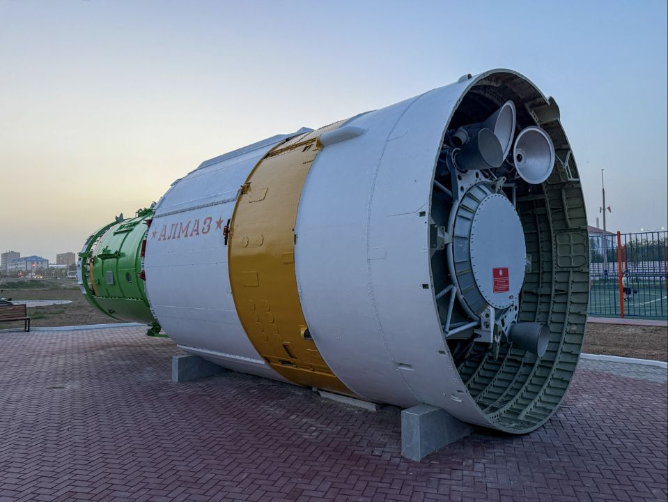 Cylindrical Almaz orbital station displayed outdoors with its rear structure facing the camera.